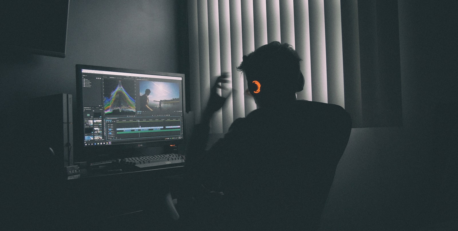 A lit editing workstation glowing in a darkened edit suite.